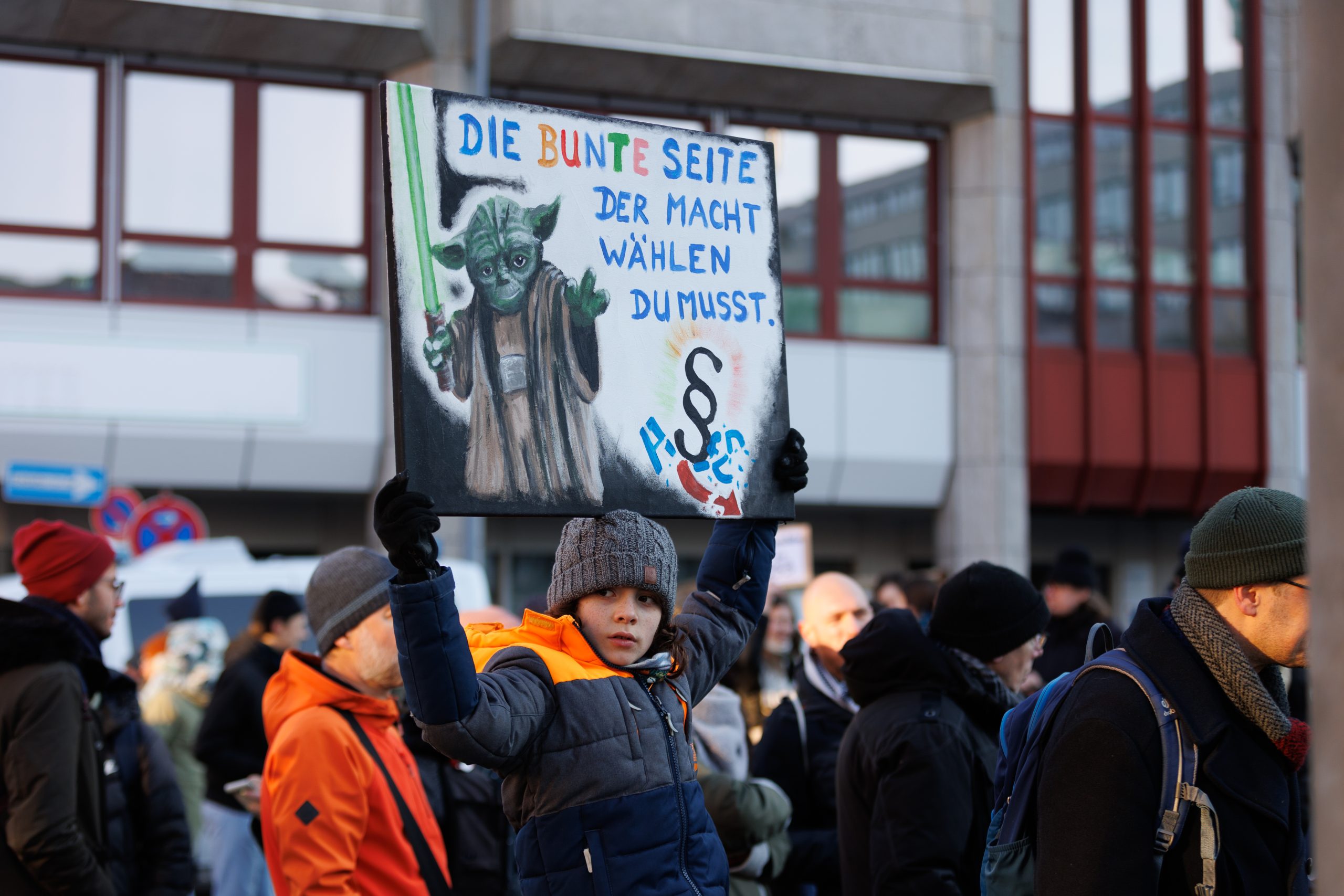 Ein Junge hält bei der Demo gegen Rechtsextremismus am 20. Januar 2024 in Nürnberg ein Plakat in die Höhe. Darauf eine Yoda-Zeichnung und der Satz "Die bunte Seite der Macht wählen du musst"