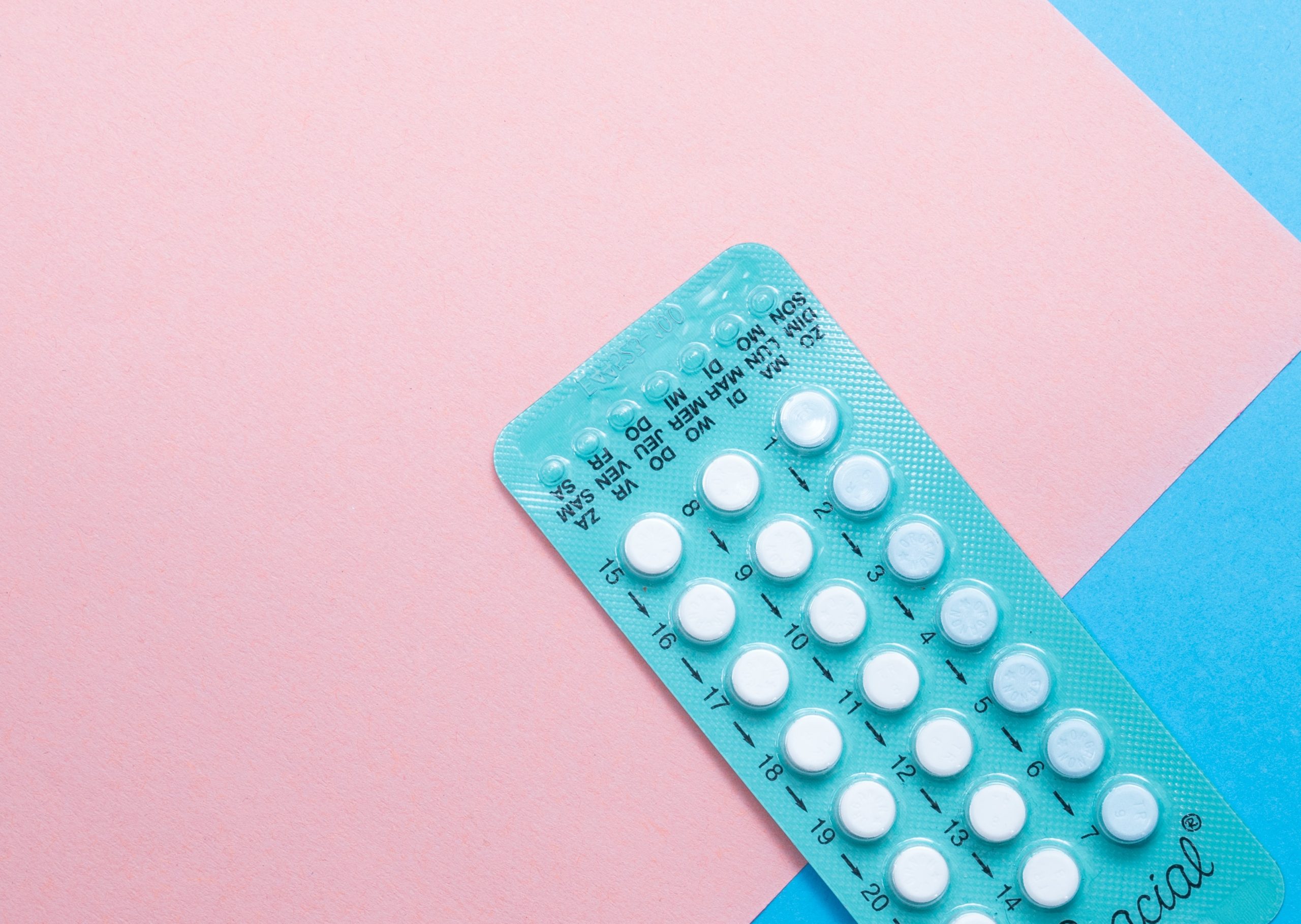 Pillenverpackung auf rosa und blauen Hintergrund